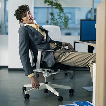 Image of a man slumped in an office chair with a glazed look on his face.
